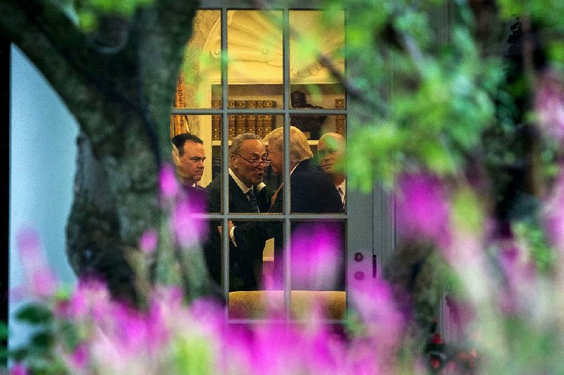 President Donald Trump confers with Senate Minority Leader Charles Schumer during a meeting with congressional leaders Wednesday in the White House Oval Office. 