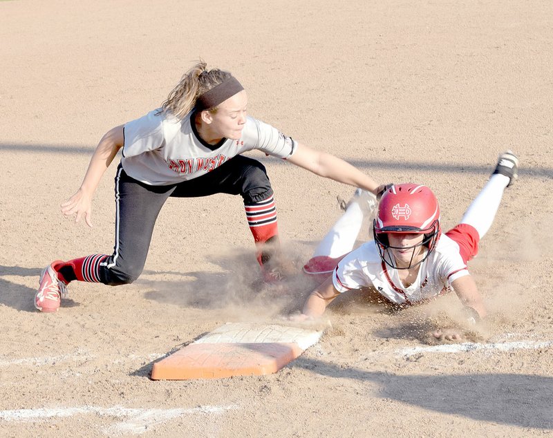 Photo by Rick Peck McDonald County first baseman Maddie Colvin is just a fraction of a second late in putting a tag on an Aurora runner during the Lady Mustangs&#8217; 12-0 win on Aug. 31 at MCHS.