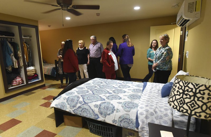 NWA Democrat-Gazette/FLIP PUTTHOFF Eva Terry (second from right), development director at Peace at Home Family Shelter, shows one of the new rooms Wednesday at the shelter's expansion celebration. A second floor was planned when the Springdale location was built in 2008. Terry said she and her colleagues saw there were more people in need of assistance than they were able to shelter.