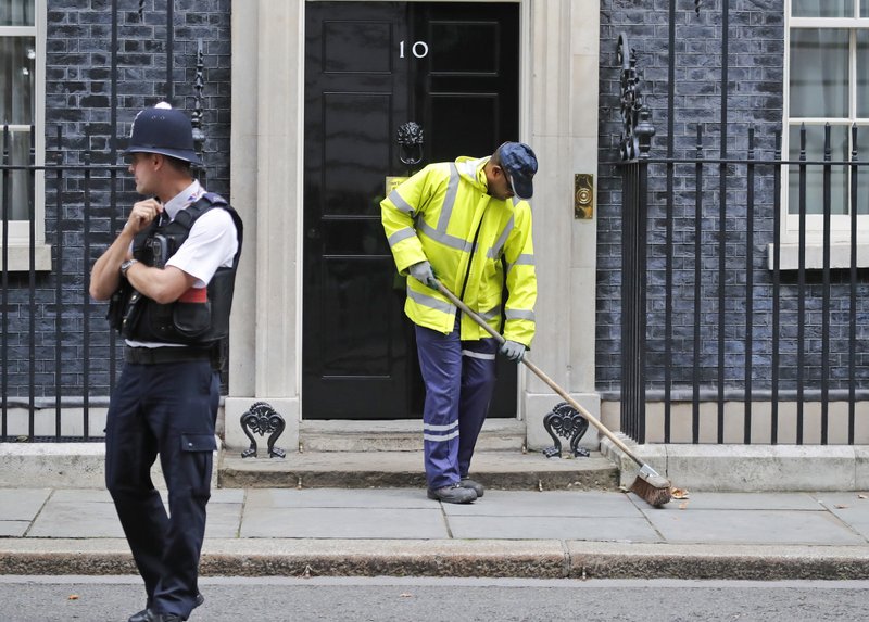 A street cleaner sweeps the pavement at 10 Downing Street in London, Wednesday, Sept. 6, 2017. A government document leaked to the media outlines proposals to force a reduction in low-skilled migrants from Europe, following Britain's Brexit EU withdrawal, although Defence Secretary Sir Michael Fallon insisted the Home Office document does not represent the Government's final position.(AP Photo/Frank Augstein)