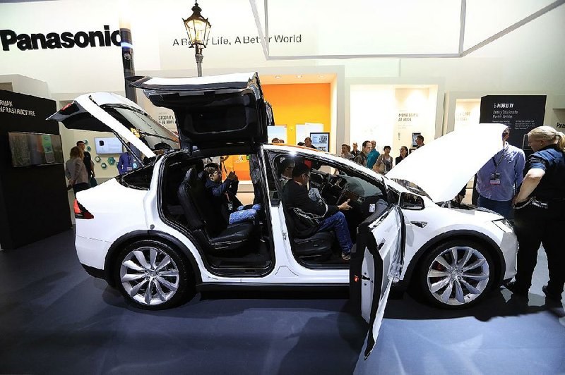Visitors inspect a Tesla Co. Model X electric automobile, fitted with Panasonic batteries, on the Panasonic Corp. exhibition stand at the IFA Consumer electronics show in Berlin on Friday.