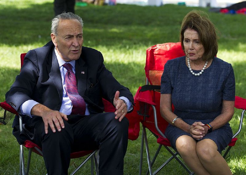 House Minority Leader Nancy Pelosi and Senate Minority Leader Charles Schumer talk Thursday with people holding a fast on Capitol Hill to protest the ending of an immigration program. 