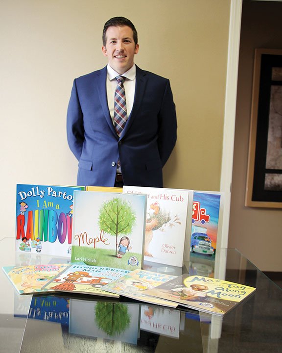 Chris Ledbetter, the current president of the Saline County Young Professionals Network, stands behind some of the books his daughter has been given through Imagination Library of Saline County. YPN is hosting a drive-thru fundraiser for the program on Thursday called Fish ’N Books, beginning at 11:30 a.m. at Park Place Baptist Church in Bryant. The cost is $12 a plate.