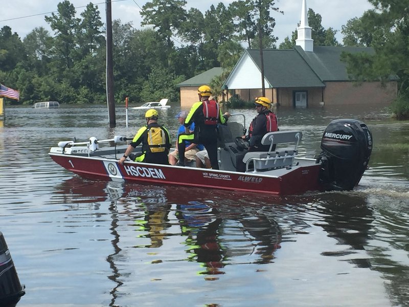 Members of Arkansas Task Force One and Arkansas Game and Fish commission drive a boat on the water above the streets of Kountze, Texas. The crews worked to transport people and supplies last week.  