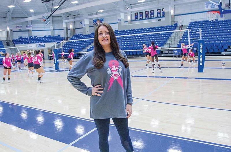 Andrea Bailey-Fournier, assistant coach for the Conway High School volleyball team, stands in Buzz Bolding Arena as the team practices. She initiated Pink Night in 2009 to raise money for cancer research, but now the proceeds go to an individual. Pink Night games will be from 5-9 p.m. Sept. 28 at the arena, and money raised from raffle-ticket sales and a silent auction will go to Savannah Westover, a 13-year-old Conway student with bone cancer.