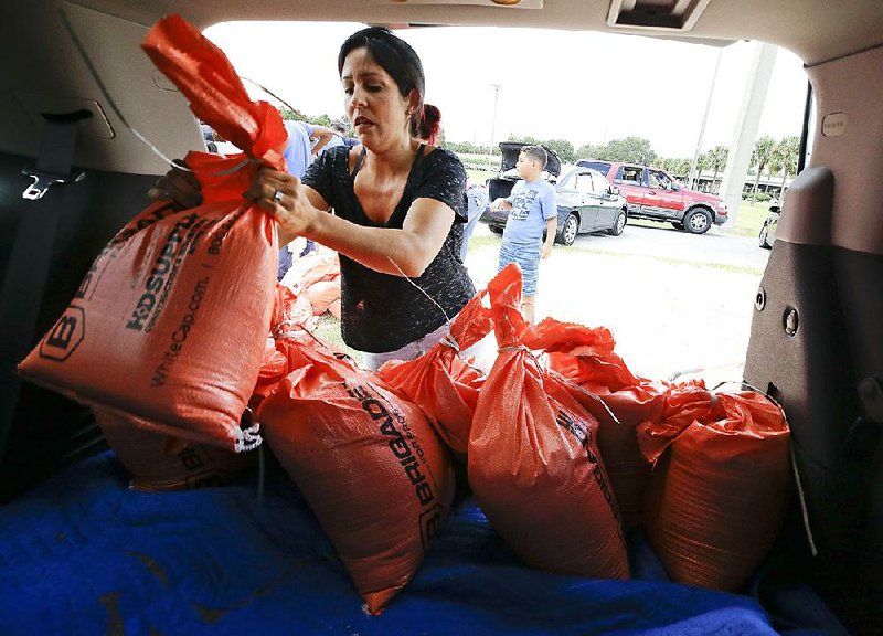 Lilimar Garcia loads sandbags in her vehicle Friday in Orlando, Fla., ahead of the arrival of Hurricane Irma. Lines stretched for miles and people waited several hours to get the sandbags. 
