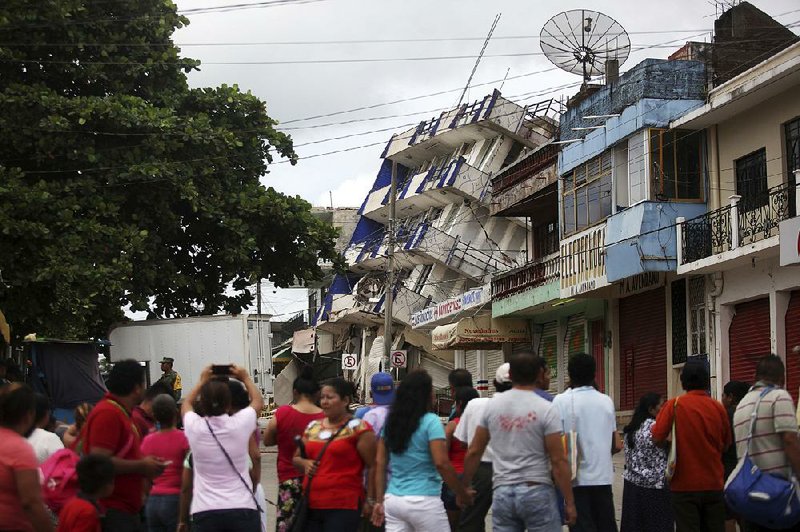 A crowd gathers near a partially collapsed hotel Friday in Matias Romero in Mexico’s Oaxaca state. Dozens of earthquake deaths were confirmed in Oaxaca state. 