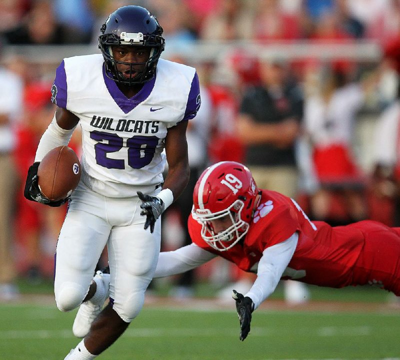 El Dorado running back Shun Levingston (28) eludes a tackle by Cabot safety Zhane Harper during the Wildcats’ 28-24 victory over the Panthers on Friday at Panther Stadium in Cabot. Levingston led the Wildcats with 4 catches for 104 yards and 2 first-half touchdowns. For more high school football photos, visit arkansasonline.com/galleries.