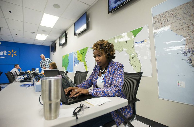 Latoya Haliburton works Friday at Wal-Mart’s emergency operations center in Bentonville to make sure suppliers in Tampa, Fla., can stock necessary merchandise at Wal-Mart stores in the hurricane zone