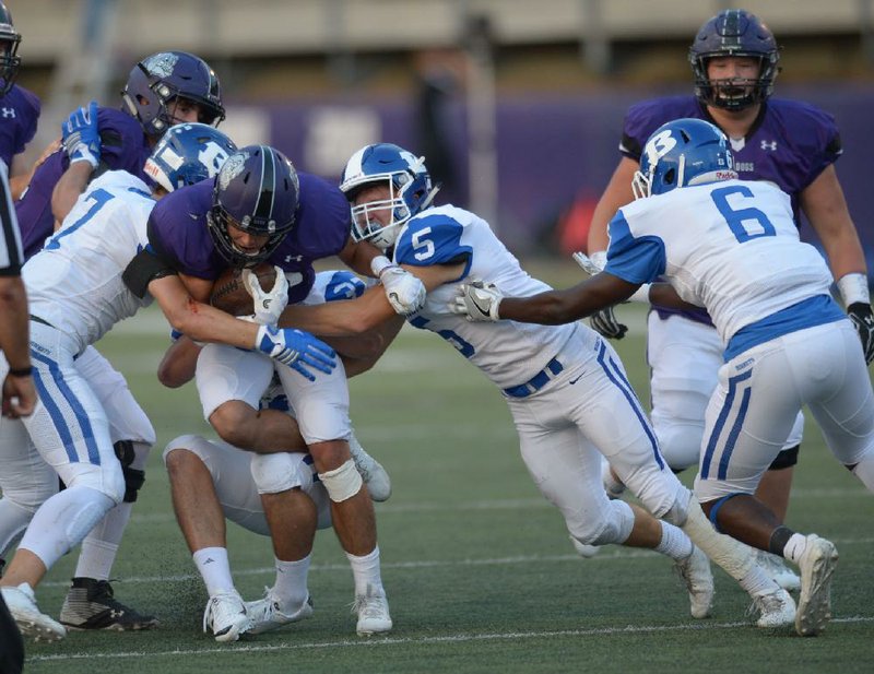 Fayetteville running back Jackson White (center left) is tackled by a group of Bryant defenders Friday in Fayetteville.