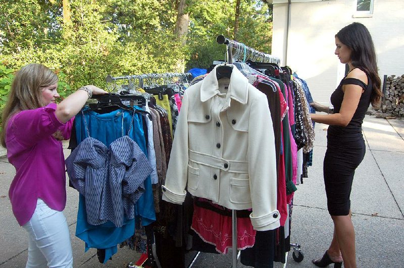 Tiffany Robinson, business manager for Barbara/Jean Ltd., and store buyer Angela Strauss sort new and gently used clothing to be sold at the fourth annual Pop Up Shop, to be held Friday and Saturday as a benefit for Women and Children First. Early birds will have the chance to attend the preview party Thursday.