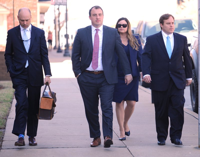 File Photo/NWA Democrat-Gazette/ANDY SHUPE Former state Sen. Jon Woods (right) walks March 28 with his attorney Patrick Benca (far left) and others from the Benca Law Firm to the John Paul Hammerschmidt Federal Building in Fayetteville.