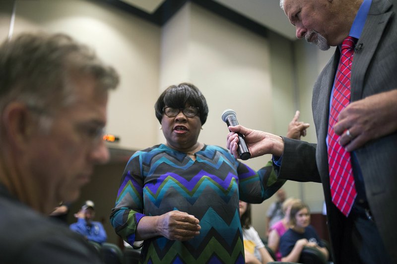 NWA Democrat-Gazette/CHARLIE KAIJO Moderator Jon Comstock (right) holds a mic for Sheree Miller of Bentonville while she shares her opinion Saturday about the Confederate statue in Bentonville&#8217;s square at the Walmart Auditorium at Northwest Arkansas Community College in Bentonville.