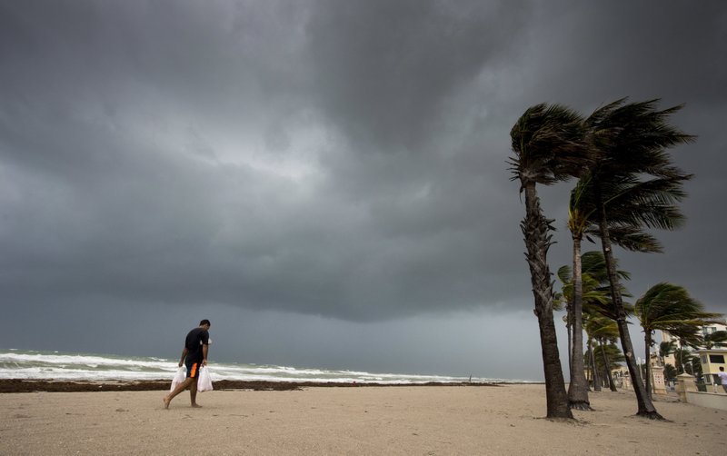 A man walks along the beach with heavy winds and threatening skies in Hollywood, Fla., as Hurricane Irma approaches the state on Saturday, Sept. 9, 2017. (Paul Chiasson/The Canadian Press via AP)
