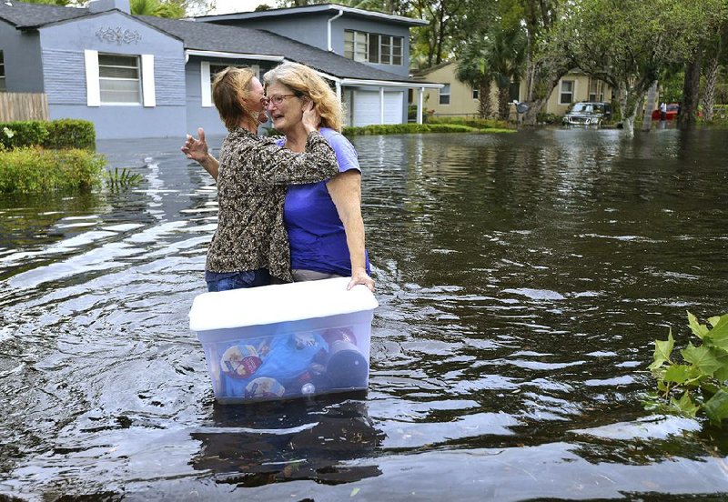 Charlotte Glaze gives Donna Lamb a teary hug as she floats out some of her belongings in floodwaters from the Ortega River in Jacksonville, Fla., on Monday, after rains from Hurricane Irma flooded the area.