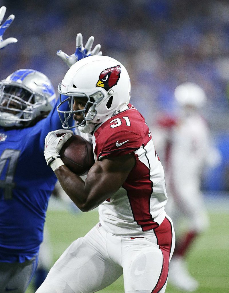 Cardinals running back David Johnson pulls in a reception Sunday against the Lions in Detroit. He dislocated his wrist in the game but is seeking a second opinion before having surgery.