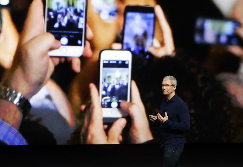 Apple Inc. CEO Tim Cook describes the functions of the iPhone 7 during a product release event in this September, 2016 photo. Two Apple-focused blogs said over the weekend that Apple will release three phones today: the iPhone 8, iPhone 8 Plus and iPhone X.