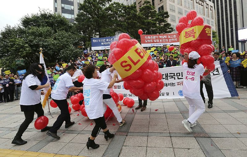 Members of Korea Freedom Federation beat balloons symbolizing North Korean weapons during a rally Monday in Seoul, South Korea, to denounce North Korea’s nuclear test.