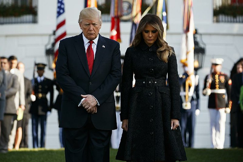 President Donald Trump and fi rst lady Melania Trump stand during a moment of silence to mark the anniversary of the Sept. 11 terrorist attacks, on the South Lawn of the White House on Monday in Washington.