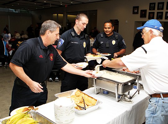 The Sentinel-Record/Richard Rassmussen GIVING BACK: St. Mary's of the Springs Catholic Church member Don Borchert, right, serves breakfast to Hot Springs Fire Department Driver Shannon McDaniel, left, HSPD Officer Shawn Woodall and Officer Richard Nunez during a first responder breakfast sponsored by the Squire Circle 5700 youth group, Knights of Columbus Council 6419 and the congregations of St. Mary's and St. John's churches Monday.