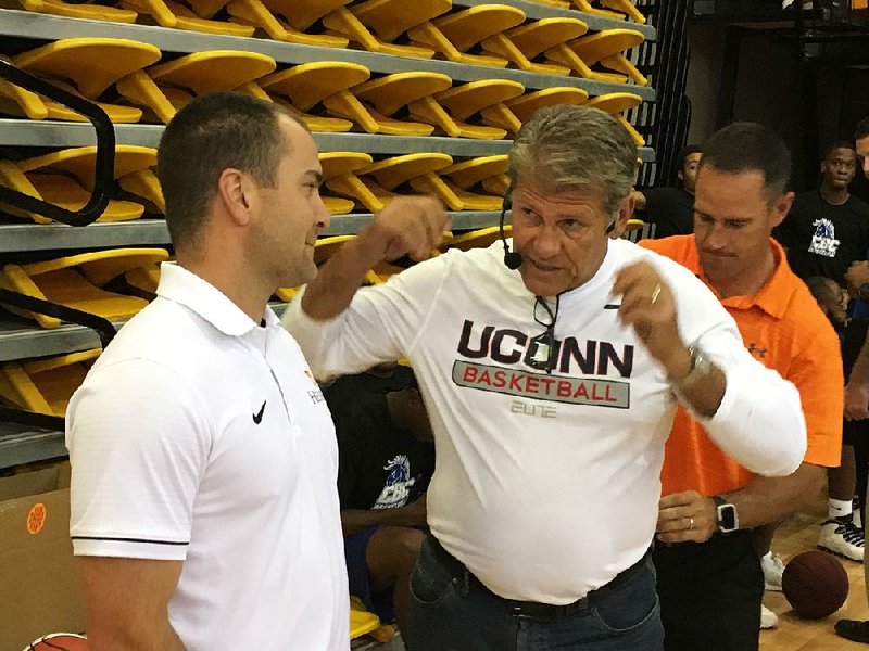 Connecticut women’s basketball Coach Geno Auriemma (middle) talks to Hendrix women’s Coach Drew Gaeng while being wired with a microphone Tuesday before speaking to the Arkansas Basketball Coaches Association in Conway. 