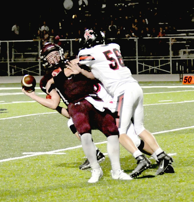 MARK HUMPHREY ENTERPRISE-LEADER Lincoln junior quarterback Caleb Lloyd is sacked by Brandon Garner of Keys, Okla. The Keys Cougars defeated Lincoln, 34-16, Friday. Lloyd injured his throwing hand in the first half. He came out and played hurt in the second half to lead Lincoln on two long scoring drives. Pain caused him to under-throw passes and he left the game in the fourth quarter.