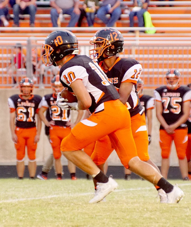 Photo by Randy Moll Gravette senior Austin O&#8217;Brien receives the handoff from Tajae White, a junior and Gravette&#8217;s quarterback, during Friday (Sept. 8, 2017) night&#8217;s game against Booneville in Lion Stadium at Gravette.