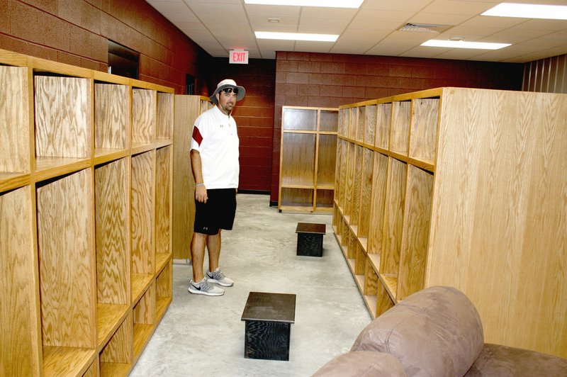 MARK HUMPHREY ENTERPRISE-LEADER Lincoln assistant football coach and head baseball coach Justin Bounds shows off the new varsity football dressing area of the newly constructed Football Fieldhouse at the high school campus. Bounds is making use of the old fieldhouse by conducting workout sessions and weight training for baseball and softball players not involved in fall sports.