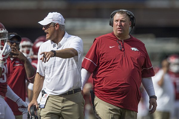 Arkansas coach Bret Bielema, right, and defensive coordinator Paul Rhoads talk to players during a game against TCU on Saturday, Sept. 9, 2017, in Fayetteville. 