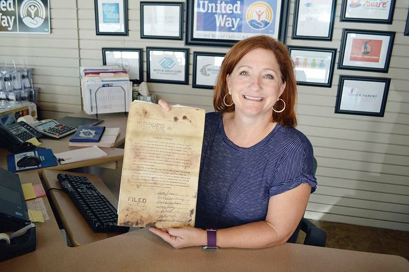 Maret Cahill-Wicks, executive director of the United Way of Central Arkansas, holds a copy of the 1957 document that formed the Faulkner Community Fund. Fifteen men and women from Faulkner County cities signed the document and formed the first board, which became the United Way agency. A 60th- birthday celebration for the organization will take place from 2-6 p.m. Saturday at the University of Central Arkansas practice field before the football game.