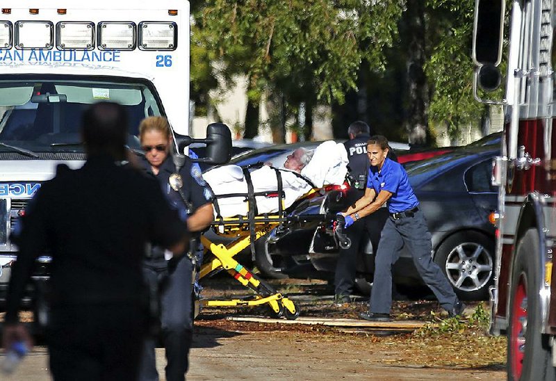 An emergency medical team moves a woman out of a nursing home in Hollywood, Fla., on Wednesday after the air-conditioning system failed. Eight people died and more than 100 had to be evacuated. 