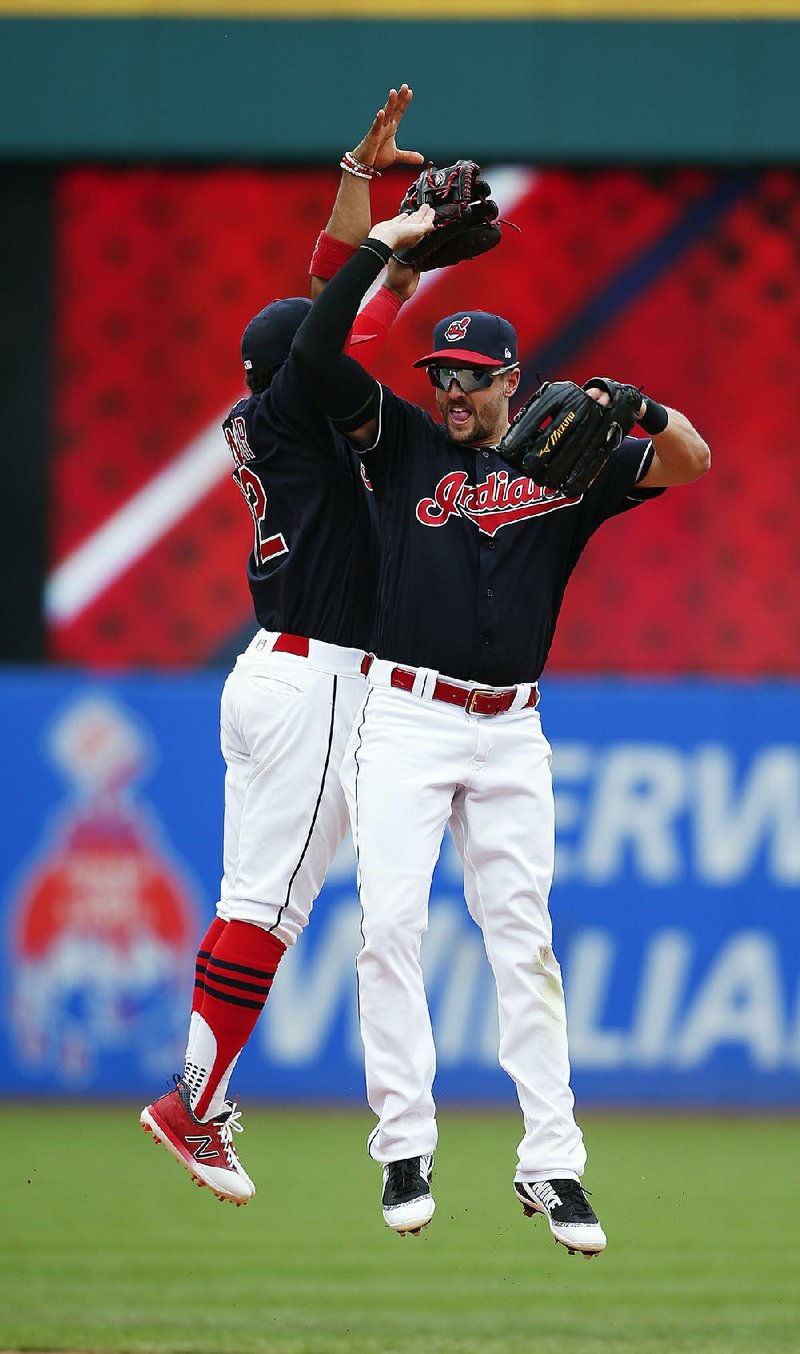 Lonnie Chisenhall (right) and Francisco Lindor celebrate after Wednesday’s 5-3 victory over the Detroit Tigers in Cleveland. It was the Indians’ 21st consecutive victory, the longest winning streak ever by an American League team. 