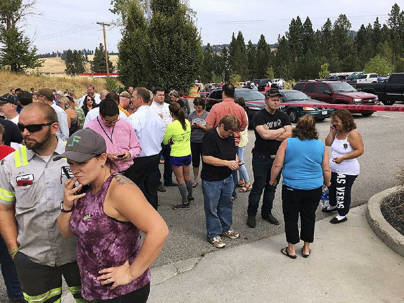 Parents gather in the parking lot behind Freeman High School in Rockford, Wash., to wait for stu- dents after a deadly shooting at the high school Wednesday. 