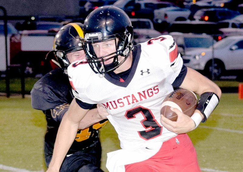 Photo by Rick Peck McDonald County quarterback Peyton Barton tries to get past a Cassville defender during the Mustangs 21-14 win on Sept. 8 at Cassville High School.