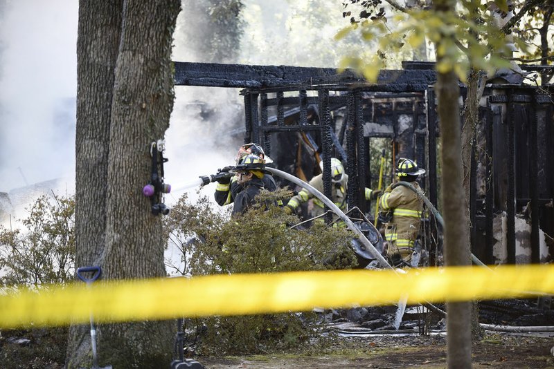 NWA Democrat-Gazette/FLIP PUTTHOFF Firefighters work the scene of a house fire Wednesday morning at 8720 Haven Drive in the Prairie Creek east of Rogers. Betty L. Morris was found dead in the house, said Marc Trollinger, Benton County fire marshal. 