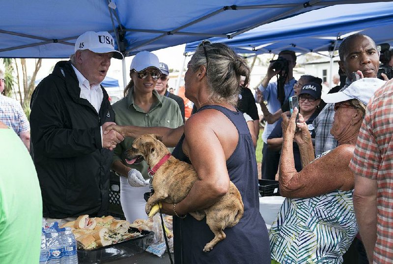 President Donald Trump and his wife, Melania (center), serve sandwiches to people affected by Hurricane Irma on Thursday in Naples, Fla. “We are there for you 100 percent,” Trump said.
