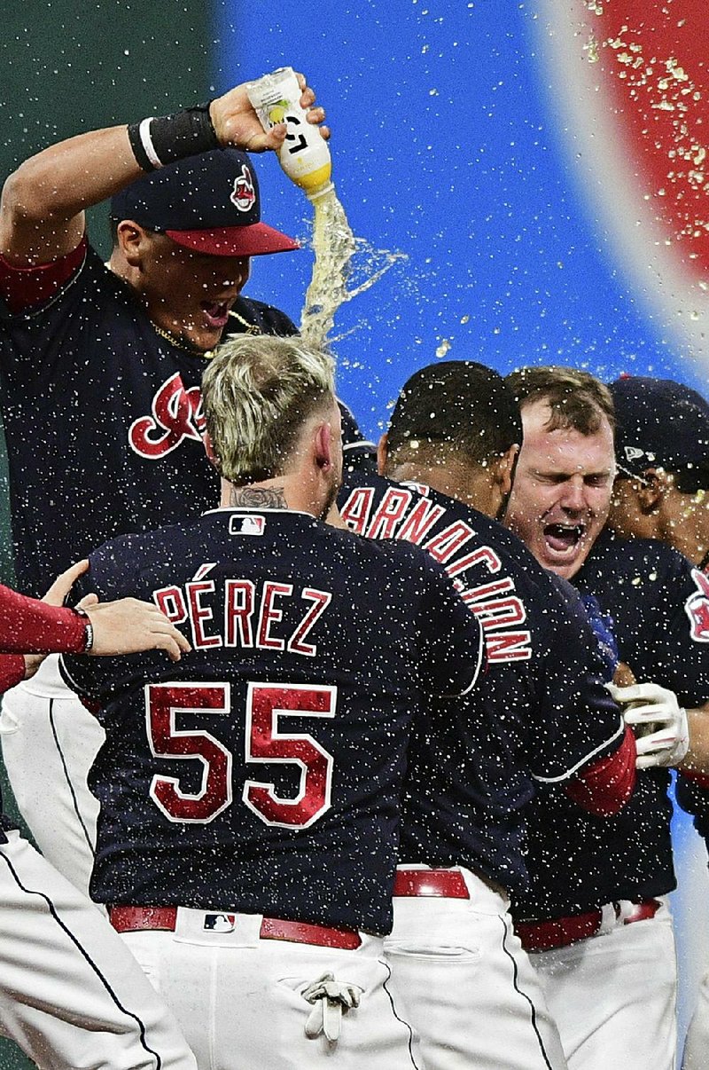 Cleveland Indians’ Jay Bruce (right) celebrates with teammates after Bruce drove in the winning run with a double off Kansas City Royals relief pitcher Brandon Maurer during the 10th inning of their game Thursday night in Cleveland. The Indians won their record-setting 22nd consecutive game, 3-2.