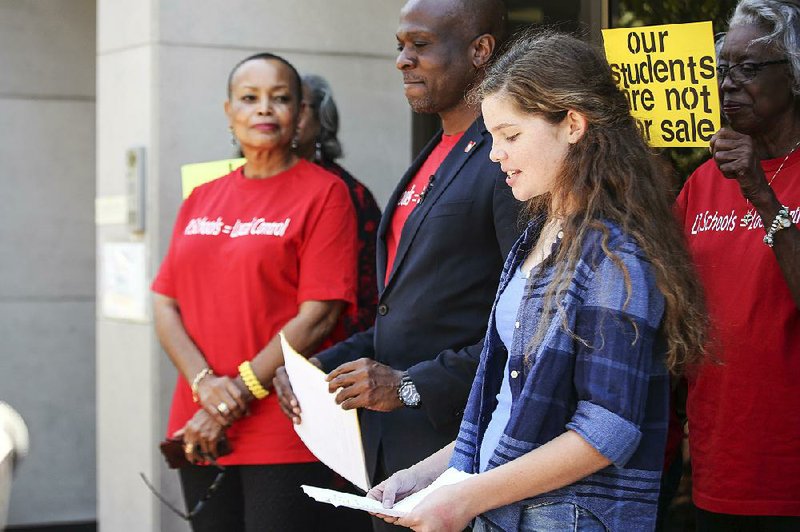 State Sen. Joyce Elliott (from left), D-Little Rock, and writer/activist Vincent Tolliver listen to Maggie Collins, an eighth-grader at Little Rock’s Horace Mann Middle School, during a news conference Thursday by Grassroots Arkansas. 