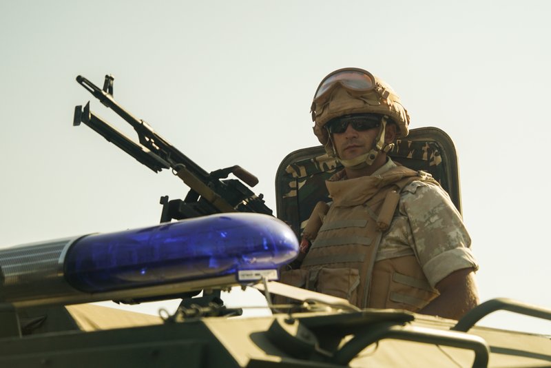 A Russian military policeman guards the area from the top of an armoured car near Homs, Syria, Wednesday, Sept. 13, 2017. Hundreds of people, mostly women and elderly men, living on the both sides which recently was a frontline between Syrian government forces and the Free Syrian Army flocked to a Russian military police check-point on Wednesday to get Russian food aid. (AP Photo)