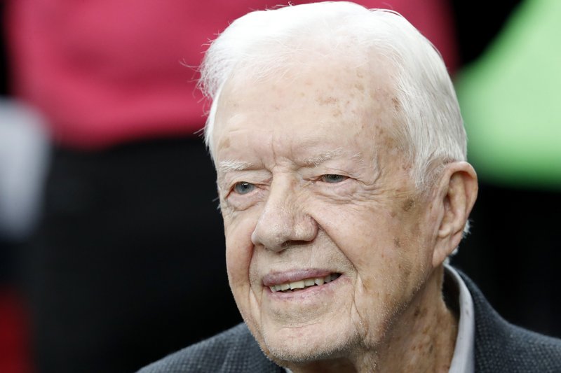 FILE - In this Oct. 23, 2016 file photo, former President Jimmy Carter sits on the Atlanta Falcons bench before the first half of an NFL football game between the Atlanta Falcons and the San Diego Chargers, in Atlanta.  (AP Photo/John Bazemore, File)