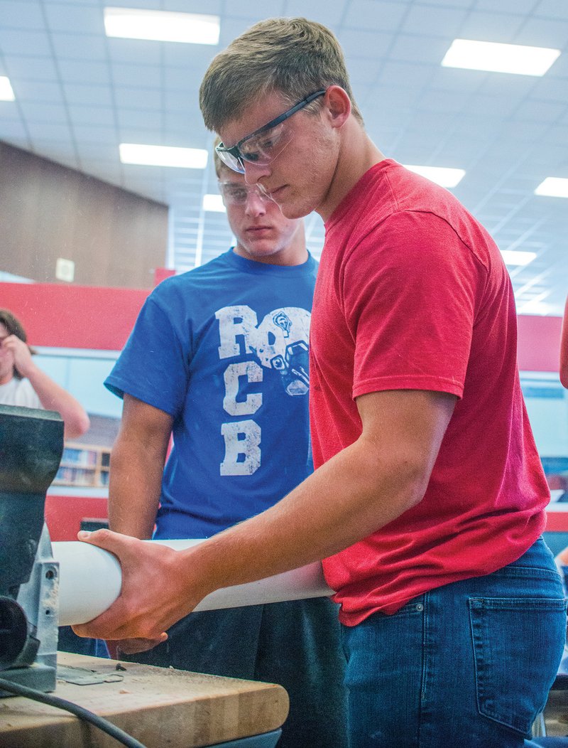 Josh Burnham, left, watches his brother, Jack Burnham, sand a piece of plastic pipe for a T-shirt cannon they are making in a pre-engineering class at Arkadelphia High School. A two-day industry fair highlighting jobs in the pre-engineering and manufacturing fields, as well as other skilled professional careers is scheduled for Sept. 27-28 at Arkadelphia High School.