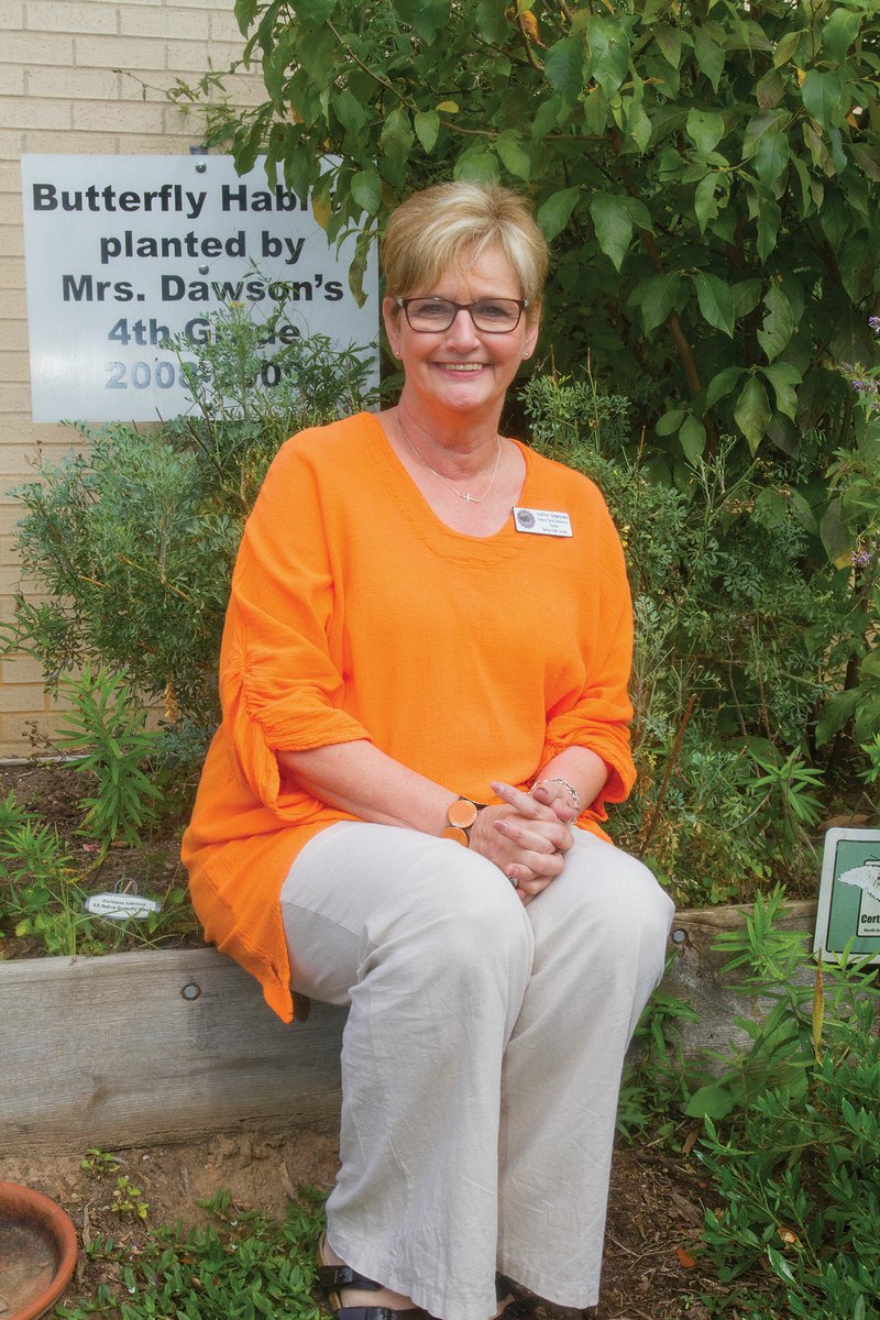 Cathy Dawson, a fourth-grade literacy teacher at Howard Perrin Elementary School in Benton, sits in the butterfly habitat she helped plant 10 years ago with her friend Pat Gipson. Dawson was recently named Teacher of the Year for the Benton School District.