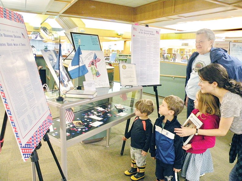 Katie Opris of Conway, far right, takes a look at the Constitution Week display at the Faulkner County Library in Conway with her children, 
Adrielle, 6, Elias, 5, and Arlon, 2. Joyce Rossi, also of Conway, joined the family to learn more about the U.S. Constitution. The Cadron Post Chapter, 
National Society Daughters of the American Revolution, set up the display, as well as similar displays at the branch libraries in Greenbrier, Mayflower and Vilonia and at the Faulkner County Fair.