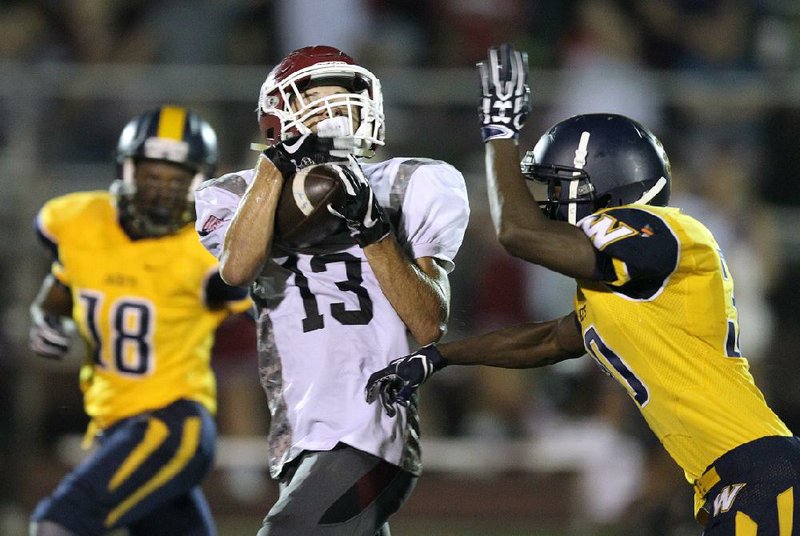 Beebe wide receiver Taylor Boyce (13) pulls in a pass over Wynne cornerback Aaron Guinn, right, during the second quarter Friday at Erwin Stadium in Beebe. Wynne won 35-14.