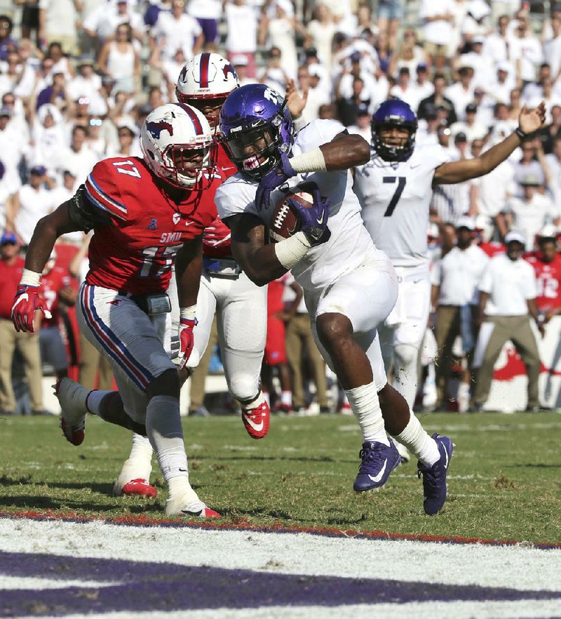 TCU running back Darius Anderson (6) avoids SMU linebacker Jordon Williams to score a touchdown Saturday during the No. 20 Horned Frogs’ 56-36 victory over the Mustangs in Fort Worth.