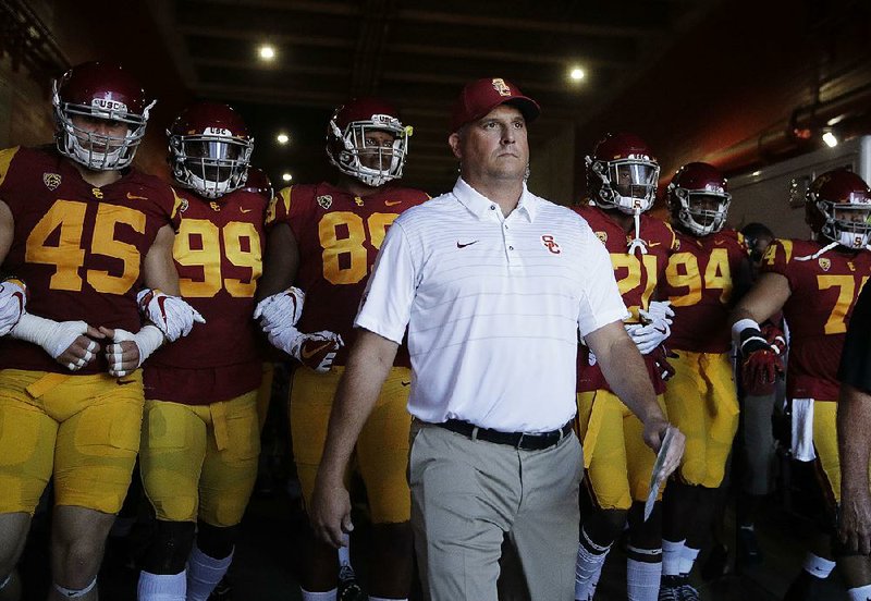 The No. 4 Southern Cal Trojans, led by Coach Clay Helton (middle), have won 11 consecutive games, including last season’s Rose Bowl. 