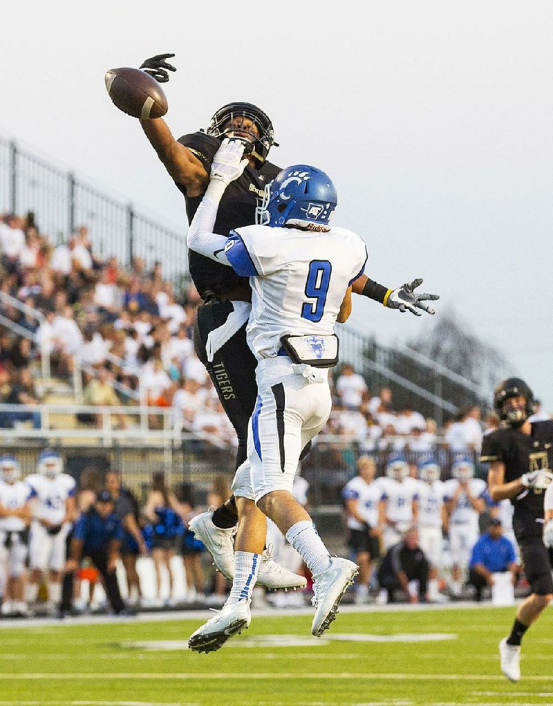 Conway’s Will Kennedy (9) breaks up a pass intended for Bentonville’s Kam’ron Mays-Hunt during the Wampus Cats’ 35-16 victory over the Tigers on Friday in Bentonville.
