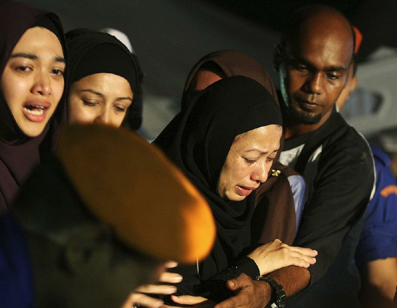 Relatives mourn Friday during a mass funeral for victims of a school fi re outside of Kuala Lumpur, Malaysia.
