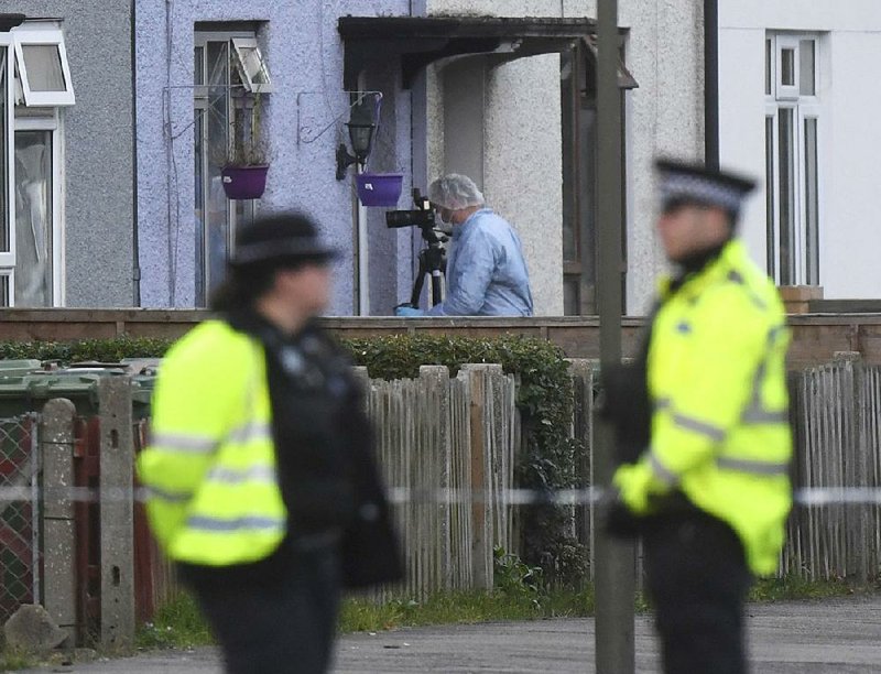 Police and forensic officers work Saturday at a property in southwest London as they investigate Friday’s subway bombing. A suspect in the bombing was arrested Saturday.  