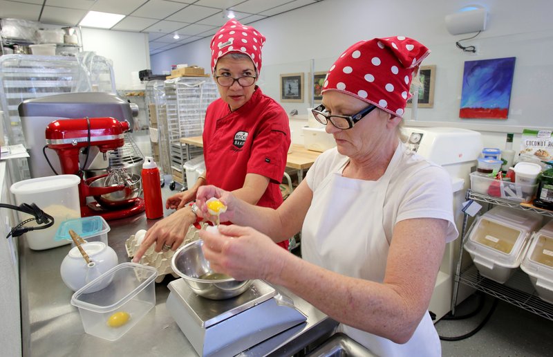 NWA Democrat-Gazette/DAVID GOTTSCHALK Daymara Baker (left), owner of the Rockin' Bakery, separates eggs with Cynthia Shaver, bakery assistant.